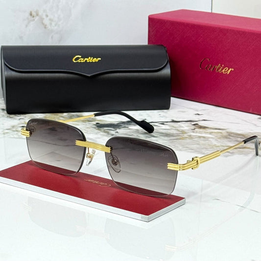 Cartier rimless sunglasses with gold metal frames and dark gray gradient lenses, displayed on a red stand with the black hard case and pink Cartier box behind on a white marble surface.